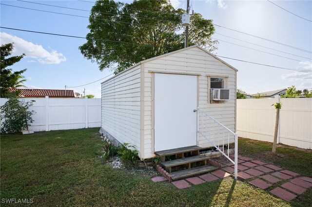 view of outdoor structure featuring a lawn and cooling unit