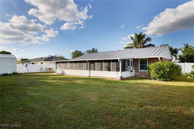 rear view of house with a sunroom, cooling unit, and a yard