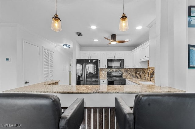 kitchen with sink, white cabinets, black appliances, and decorative light fixtures