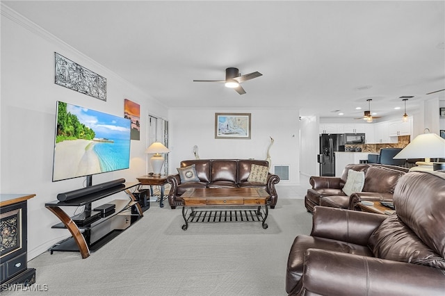 carpeted living room featuring ceiling fan and ornamental molding