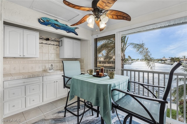 interior space featuring light tile patterned floors, ceiling fan, and sink