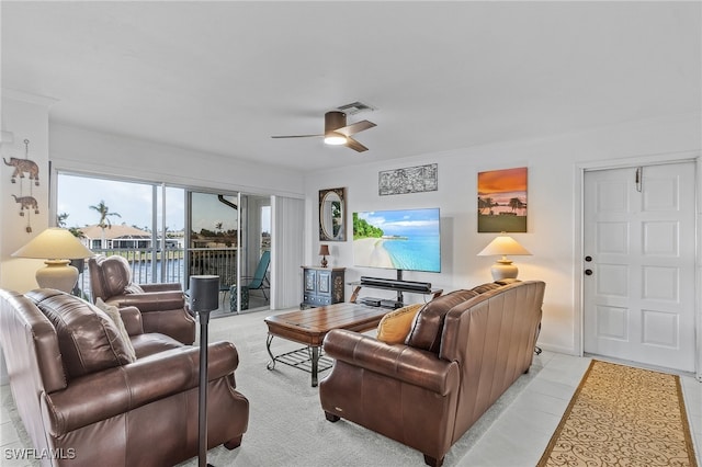 living room featuring ceiling fan, light tile patterned floors, and ornamental molding