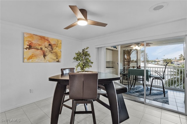 tiled dining room featuring ceiling fan and ornamental molding