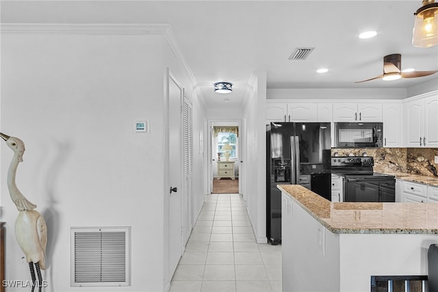 kitchen with light stone countertops, light tile patterned floors, crown molding, white cabinets, and black appliances