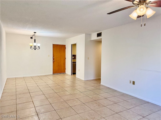 spare room featuring ceiling fan, light tile patterned floors, and a textured ceiling