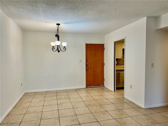 unfurnished room featuring a chandelier, light tile patterned flooring, and a textured ceiling