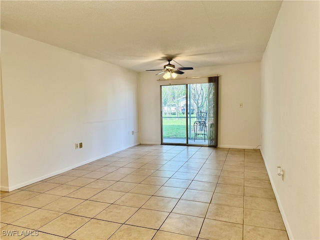 spare room with ceiling fan, light tile patterned floors, and a textured ceiling