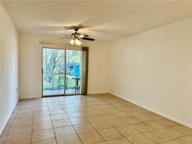 empty room with ceiling fan, light tile patterned floors, and a textured ceiling