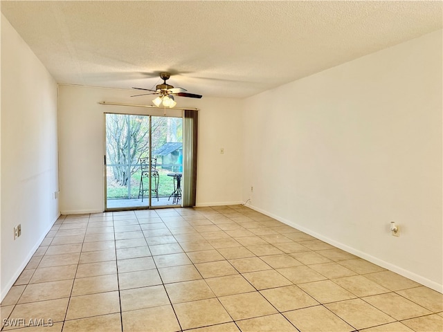 unfurnished room with ceiling fan, light tile patterned floors, and a textured ceiling