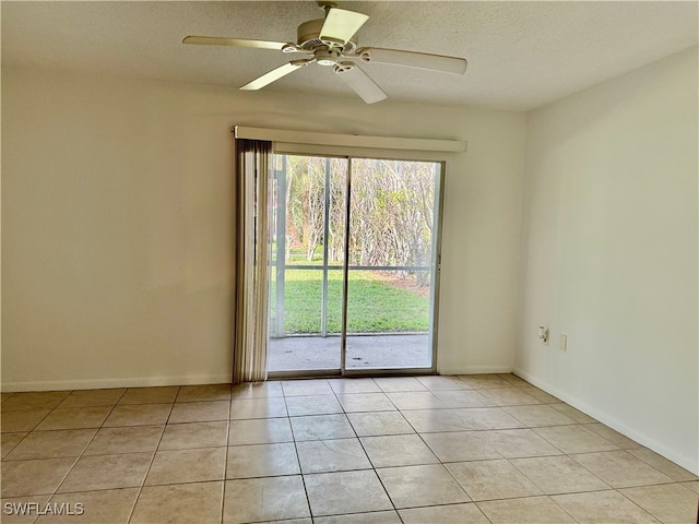 tiled empty room with ceiling fan and a textured ceiling