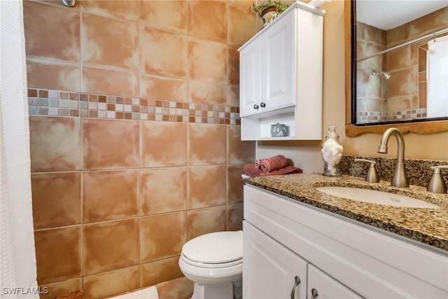 bathroom featuring vanity, tile walls, and toilet