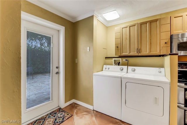 clothes washing area with cabinets, light tile patterned flooring, ornamental molding, and independent washer and dryer