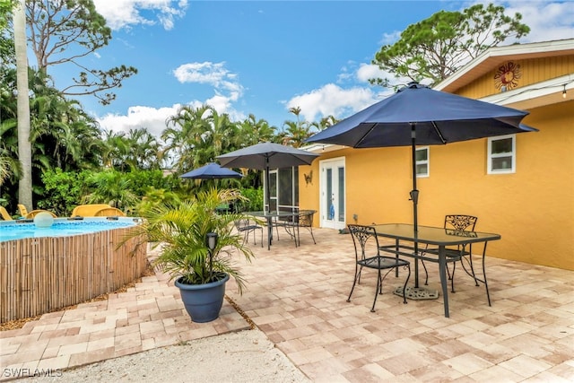 view of patio / terrace featuring a swimming pool and french doors