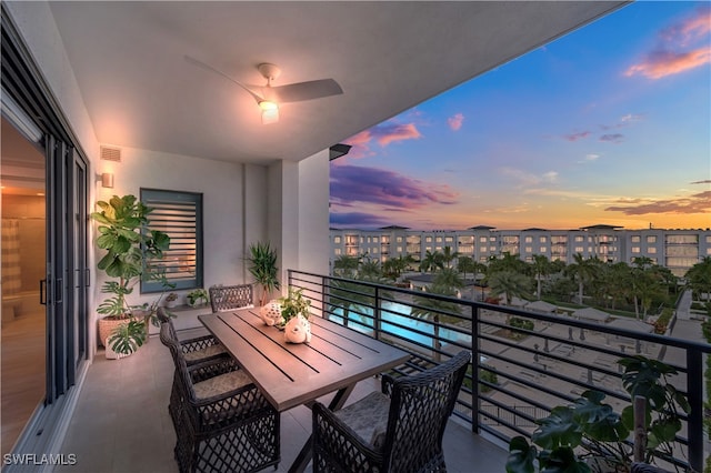 balcony at dusk featuring ceiling fan