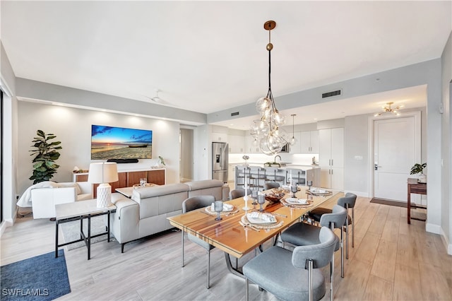 dining area with light hardwood / wood-style flooring and sink