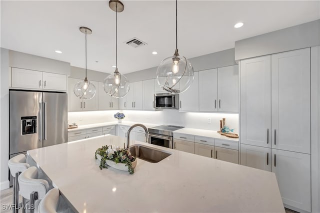 kitchen featuring pendant lighting, stainless steel appliances, sink, and a breakfast bar area