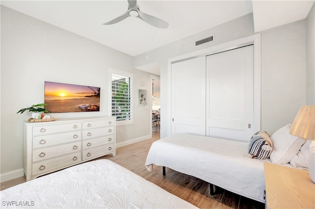 bedroom featuring light wood-type flooring, ceiling fan, and a closet