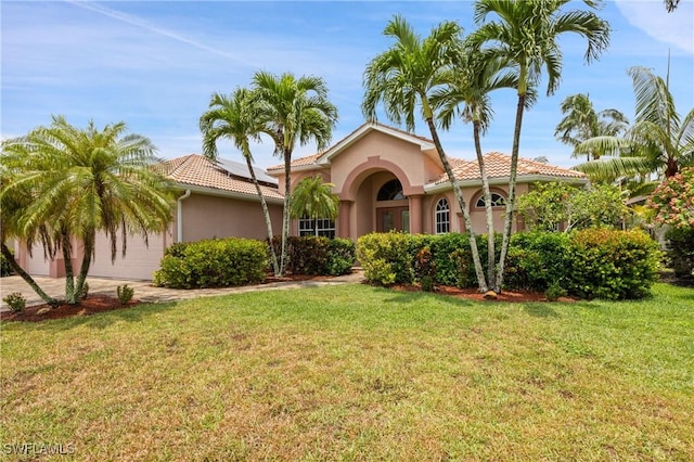 mediterranean / spanish-style house with a front yard and solar panels