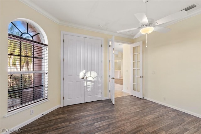 foyer entrance featuring crown molding, ceiling fan, dark hardwood / wood-style flooring, and french doors