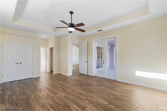 interior space featuring ceiling fan, ornamental molding, french doors, dark hardwood / wood-style flooring, and a raised ceiling