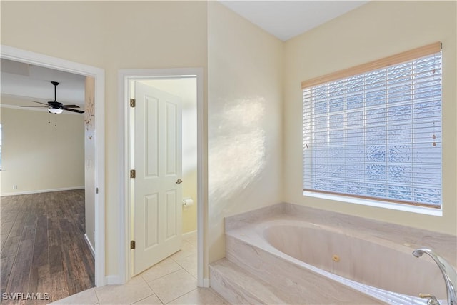 bathroom featuring ceiling fan, a tub to relax in, and tile patterned flooring