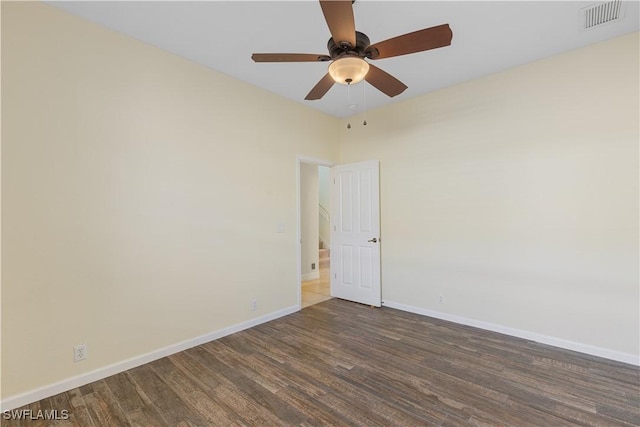 spare room featuring dark wood-type flooring and ceiling fan