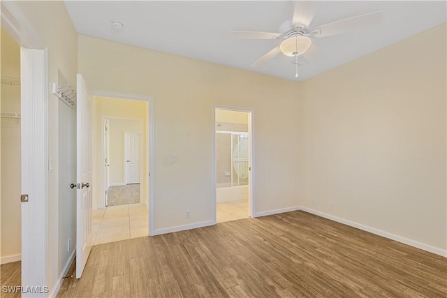 unfurnished bedroom featuring ensuite bath, light hardwood / wood-style flooring, a closet, and ceiling fan