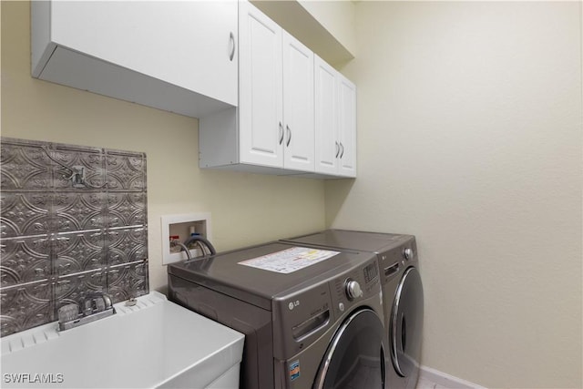 clothes washing area with cabinets, separate washer and dryer, and sink