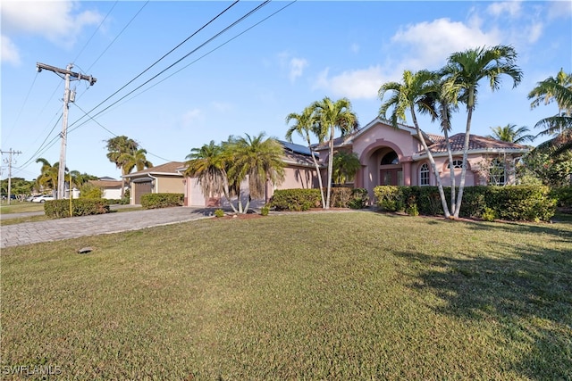 view of front of house featuring a garage and a front lawn