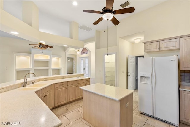 kitchen featuring a kitchen island, sink, white refrigerator with ice dispenser, and light brown cabinets