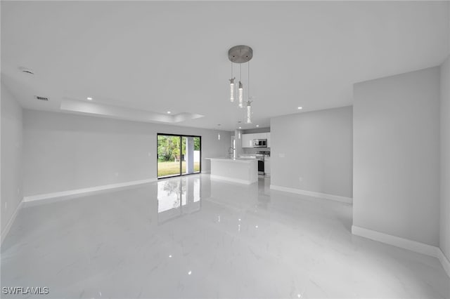 unfurnished living room featuring sink