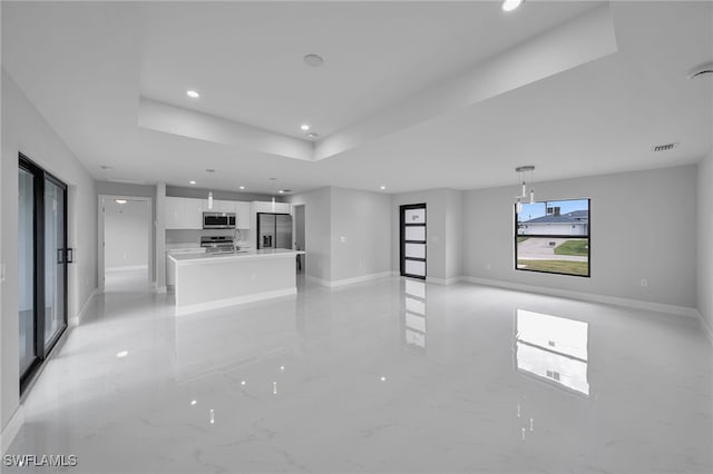 unfurnished living room featuring a tray ceiling