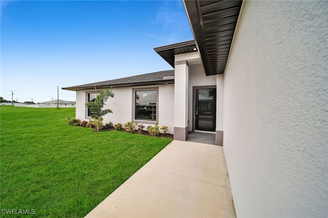 view of exterior entry with a lawn