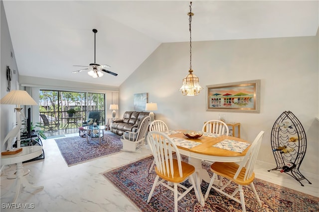 dining space with ceiling fan with notable chandelier and high vaulted ceiling