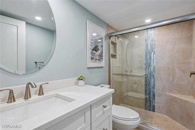 bathroom featuring vanity, toilet, and walk in shower