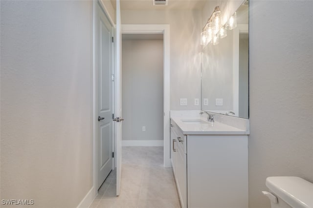 bathroom with tile patterned flooring, vanity, and toilet