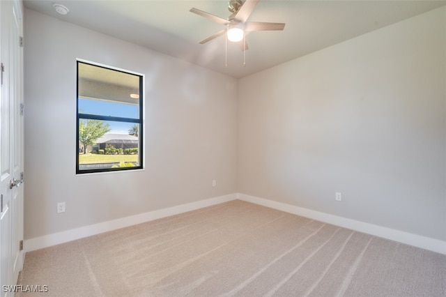 carpeted spare room with ceiling fan