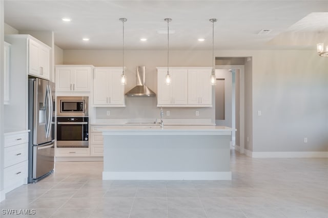 kitchen featuring white cabinetry, decorative light fixtures, wall chimney range hood, and appliances with stainless steel finishes