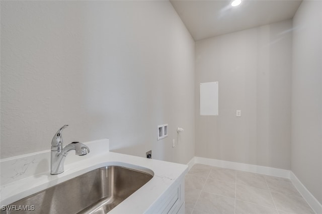 clothes washing area featuring electric dryer hookup, light tile patterned floors, sink, and hookup for a washing machine