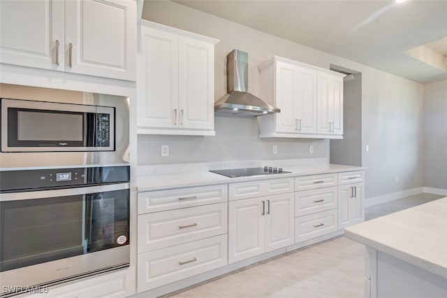 kitchen featuring wall chimney exhaust hood, white cabinetry, stainless steel appliances, and light tile patterned floors