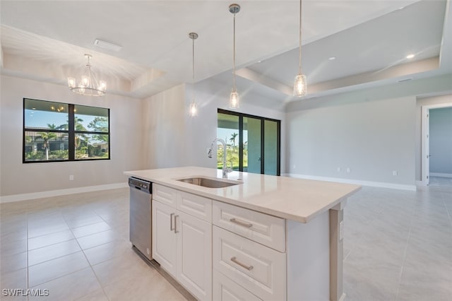 kitchen featuring stainless steel dishwasher, a healthy amount of sunlight, sink, and a tray ceiling