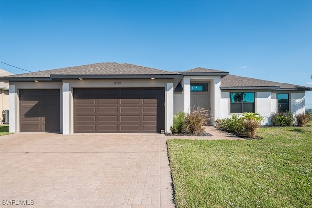 prairie-style house featuring a front lawn and a garage