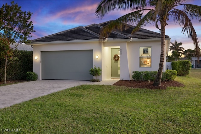 view of front of home with a yard and a garage