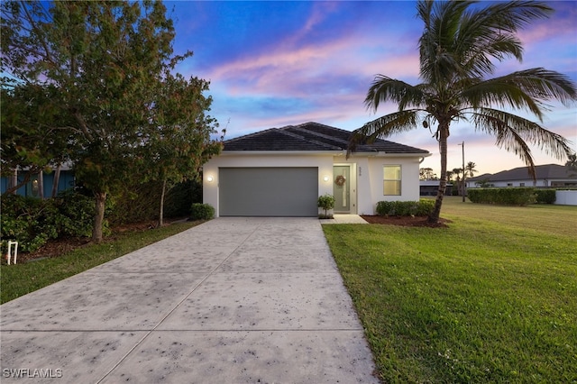 view of front of property with a garage and a lawn