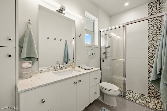 bathroom with vanity, toilet, and a shower with shower door