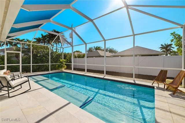 view of swimming pool featuring glass enclosure and a patio area