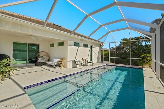 view of swimming pool with ceiling fan, a patio area, and a lanai