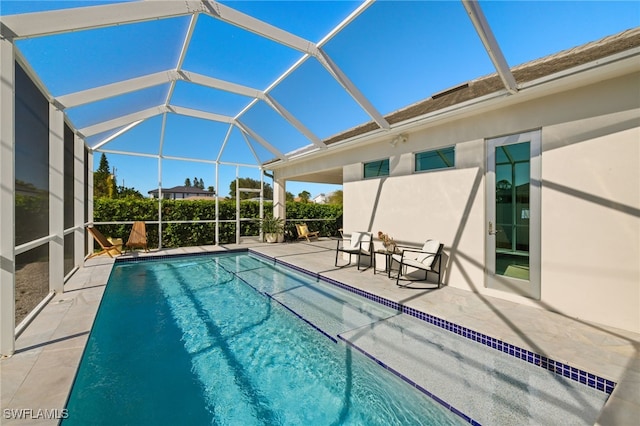 view of pool featuring glass enclosure and a patio