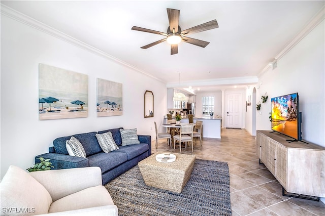 tiled living room featuring ceiling fan and ornamental molding