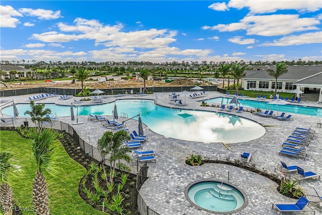 view of swimming pool with a patio and a hot tub